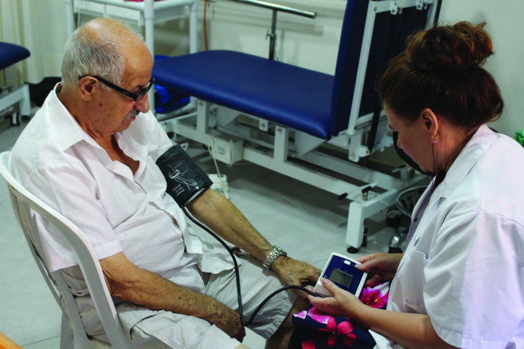 Volunteer Natalia performs a physical assessment at the Haifa Home for Holocaust Survivors.