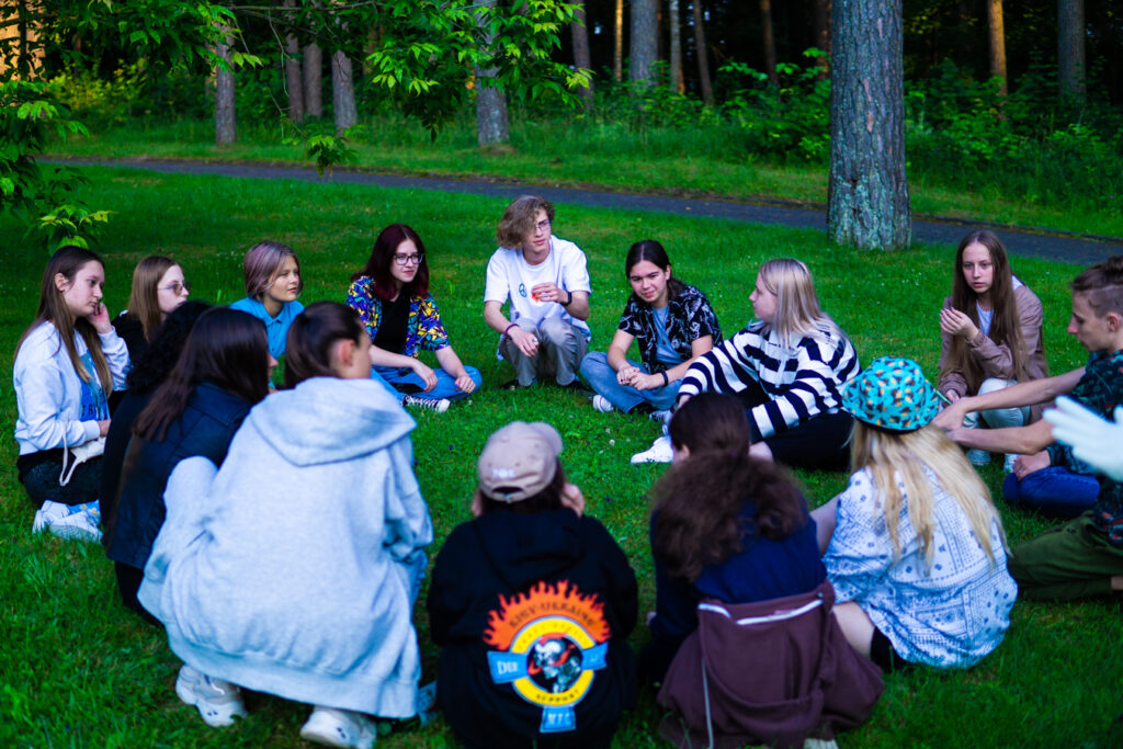 Ukraine youth sit round during recreation; Aliyah summer camp